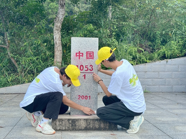 实践团成员正在擦拭界碑。
